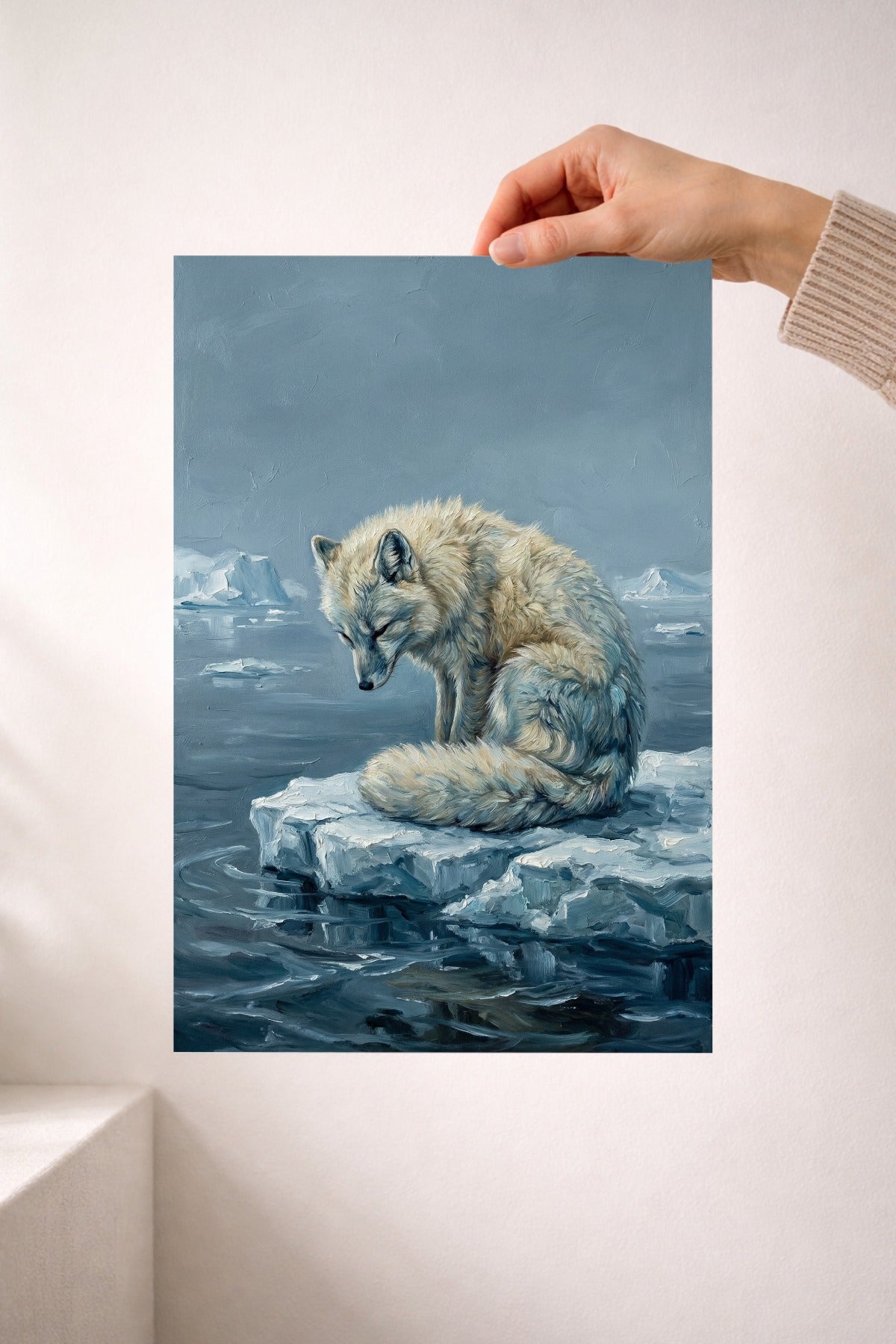 Eine Hand hält das Poster Polar Fuchs. Das gedruckte Beispielbild hat das Format A4.