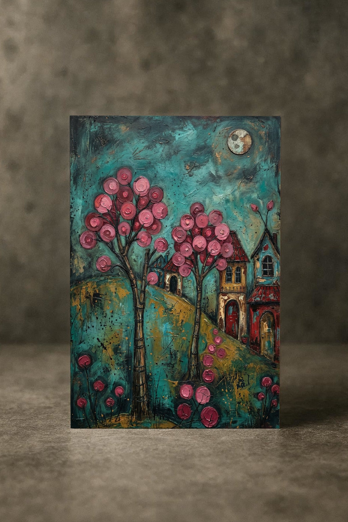 Farbenfrohes Folk-Art-Gemälde eines verträumten Dorfes bei Nacht; mit leuchtend rosa Blütenbäumen, kleinen Häusern und einem Vollmond vor einem texturreichen, türkisblauen Himmel.