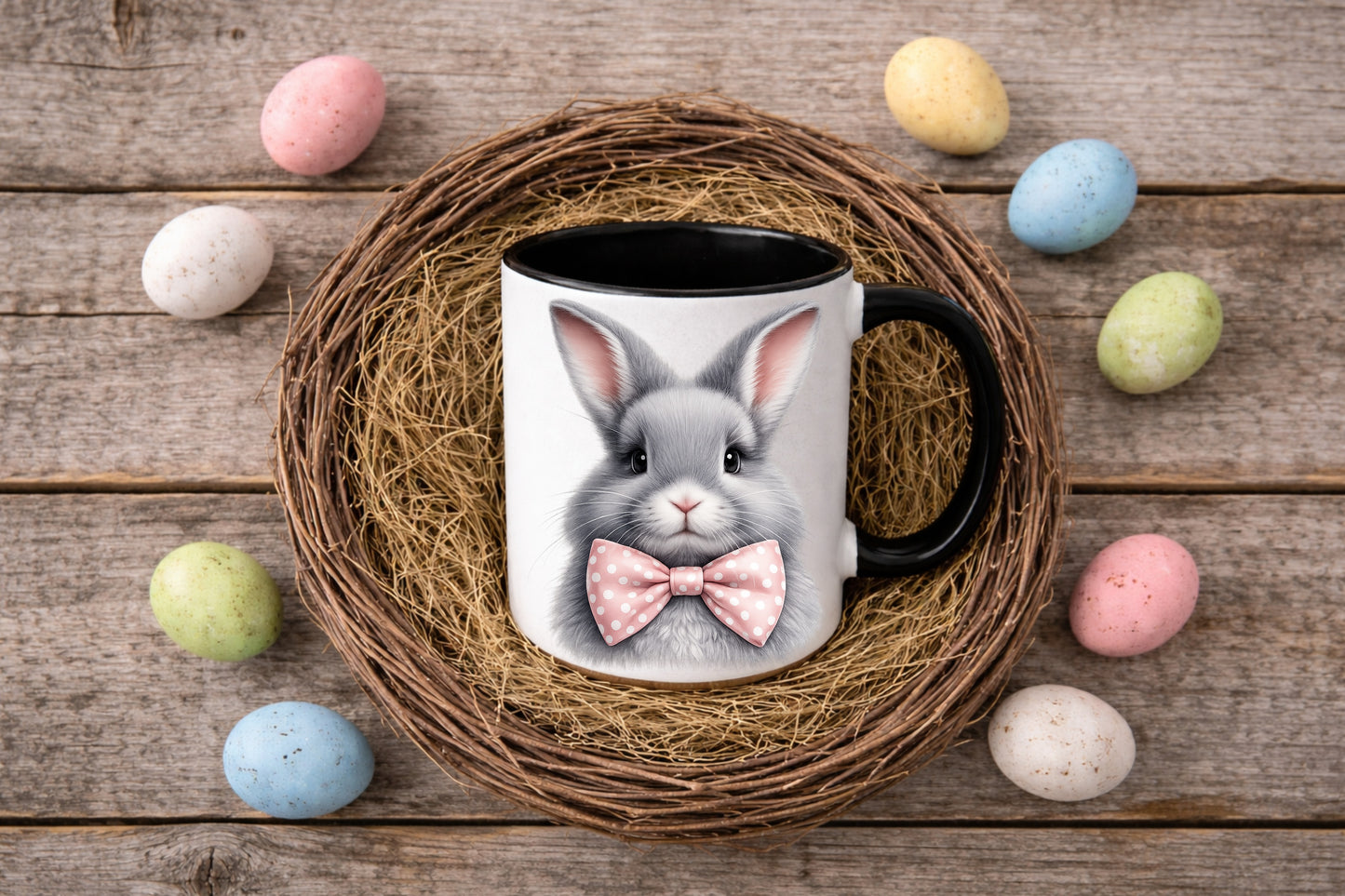 Digitales Oster-Tassenmockup: weiße Tasse mit schwarzem Henkel im Weidenkranz-Nest auf Holz, Pastell-Ostereier, freie Designfläche, Download als PNG und JPG, 3600×2400 px.