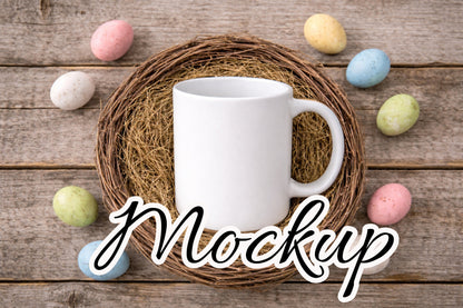 Digitales Tassenmockup: weiße Tasse im Weidenkranz-Nest auf Holz, Pastell-Ostereier rundherum, freie Designfläche, Download als PNG und JPG, 3600×2400 px.