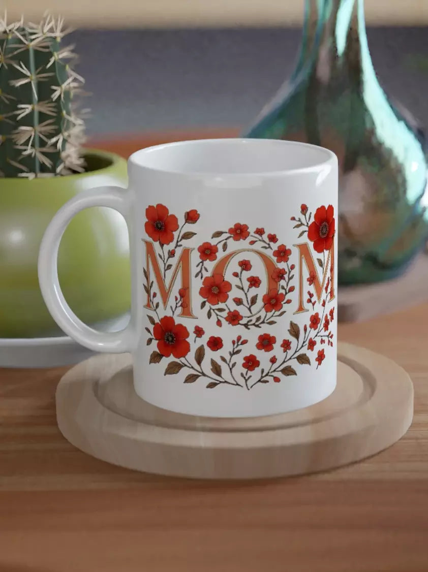 Weiße Keramiktasse mit floralem Blumenkranz und Schriftzug MOM in Rot, glänzende Oberfläche, liebevolle Geschenkidee für Muttertag oder Alltag