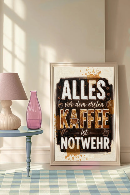 Lustiges Kaffee-Wandbild mit dem Spruch 'Alles vor dem ersten Kaffee ist Notwehr' in brauner Impasto-Typografie auf cremefarbenem Hintergrund.