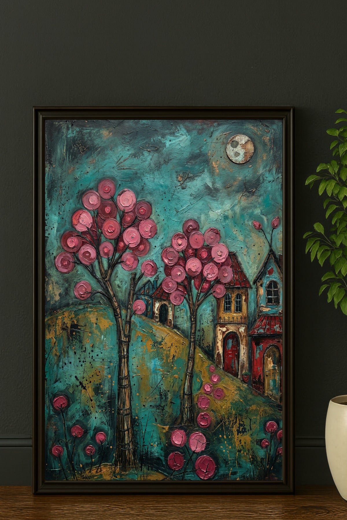 Farbenfrohes Folk-Art-Gemälde eines verträumten Dorfes bei Nacht; mit leuchtend rosa Blütenbäumen, kleinen Häusern und einem Vollmond vor einem texturreichen, türkisblauen Himmel.